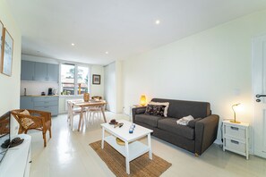 Ein modernes Wohnzimmer mit einer Couch, einem Couchtisch und einem Essbereich.