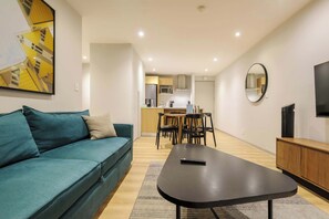Ein modernes Wohnzimmer mit einer Couch, einem Couchtisch und einem Fernseher.