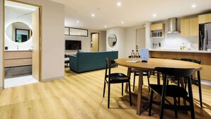 A modern kitchen with a dining area, wooden flooring, and a teal sofa. - w* | Stylish 2BR w/ AC in the Heart of Roma Sur (Ciudad de México)