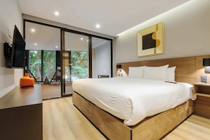Ein modernes Schlafzimmer mit einem großen Bett, einem Fernseher, einem Holz-Kopfteil und einer Glasschiebetür, die auf einen Balkon führt.