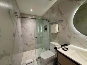 Ein modernes Badezimmer mit einer Duschkabine, einer Toilette und einem Waschtisch.