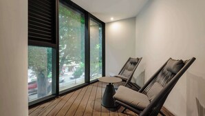 Ein modernes Zimmer mit einem großen Fenster, einem runden Tisch und zwei Stühlen.