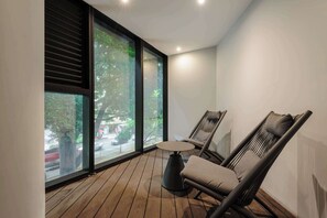Ein modernes Zimmer mit einem großen Fenster, einem runden Tisch und zwei Stühlen.