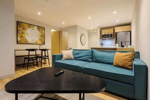 Ein modernes Wohnzimmer mit einer Couch, einem Couchtisch und einem Essbereich mit Stühlen.