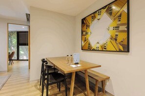 Ein moderner Essbereich mit einem Holztisch, schwarzen Stühlen und einem großen abstrakten Gemälde an der Wand.