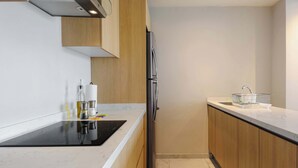 Eine moderne Küche mit eingebautem Herd, Holzschränken und einem Edelstahl-Kühlschrank.