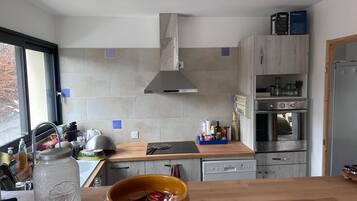 Een moderne keuken met een fornuis, oven en een groot raam.