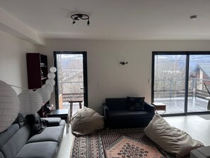 Un salon moderne avec un canapé, une table basse et un tapis à motifs.