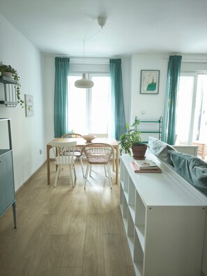 Moderni keittiö, jossa on ruokailutila, puulattia ja näkymä ulos.