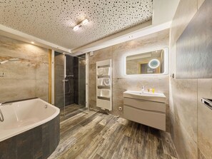 A modern bathroom with a glass-enclosed shower, a freestanding bathtub, a vanity with a mirror, and a towel rack. - Roky - Dolní náměstí by Interhome (Rokytnice nad Jizerou)