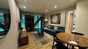 Ein modernes Wohnzimmer mit einer Couch, einem Couchtisch und einer Treppe, die in ein Obergeschoss führt.