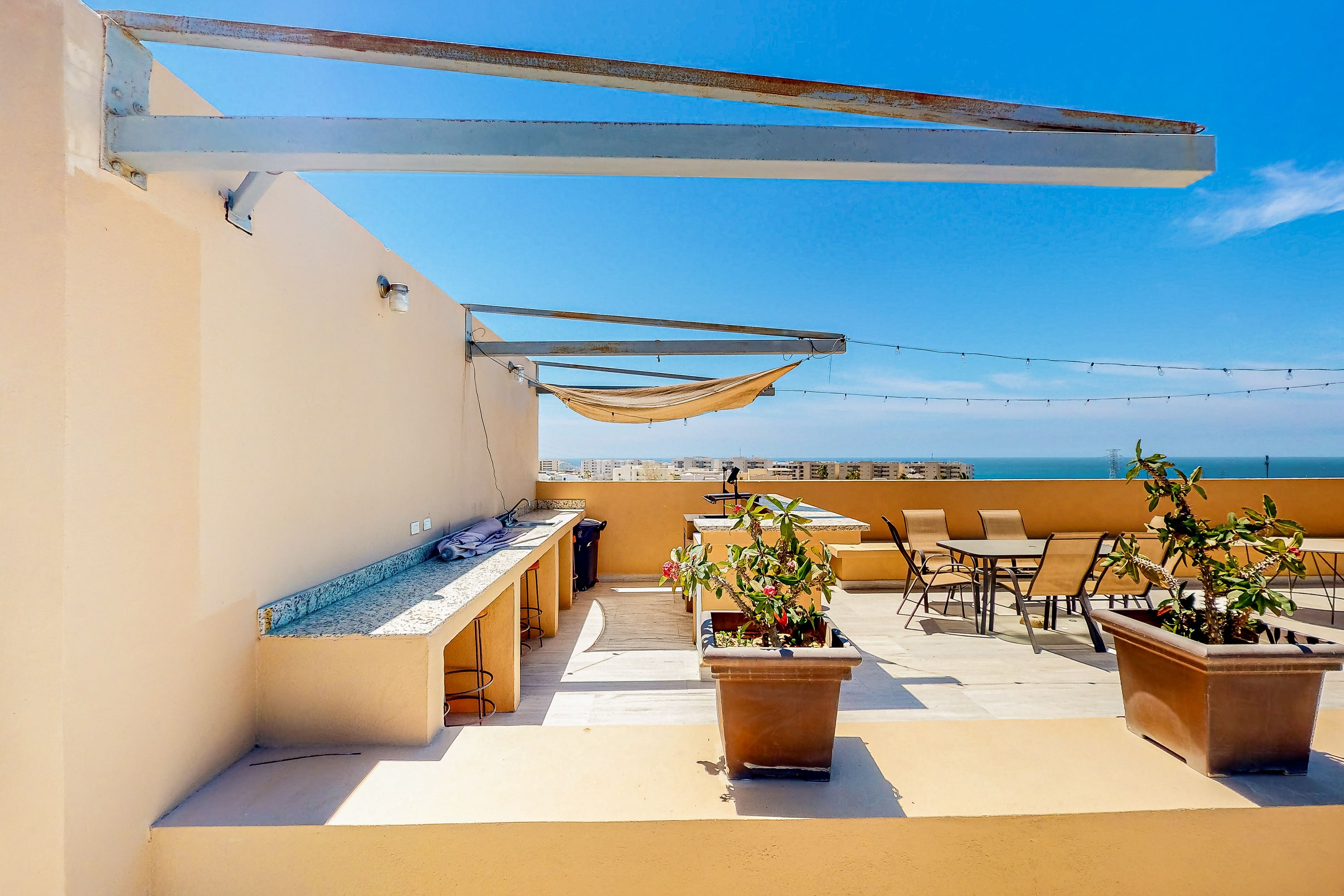 A rooftop terrace with outdoor seating, a pool table, and potted plants.