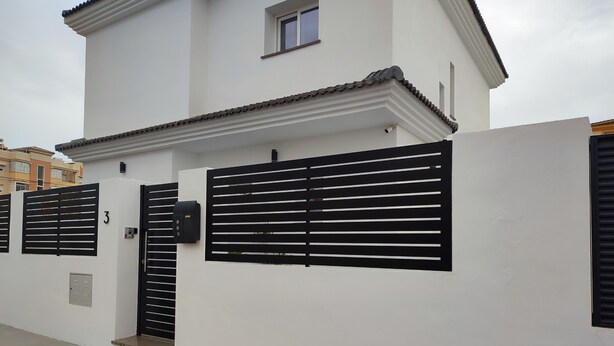 Un bâtiment blanc avec une porte noire, une boîte aux lettres et le chiffre « 3 » peint sur le mur.