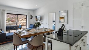 A modern kitchen with a dining area, a sofa, and a view of the outdoors. - Morgan Residences 607a @ Boutique Hotel With Pool, Gym, Spa (Cabo San Lucas)