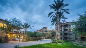 A hotel courtyard with a pool, palm trees, and a well-maintained lawn. - Toscana Treasure! Cozy 2-bedroom condo with lots of amenities in Phoenix! (Phoenix)