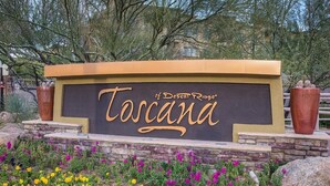 A sign with 'Toscana' written on it, surrounded by a garden with various flowers. - Toscana Treasure! Cozy 2-bedroom condo with lots of amenities in Phoenix! (Phoenix)