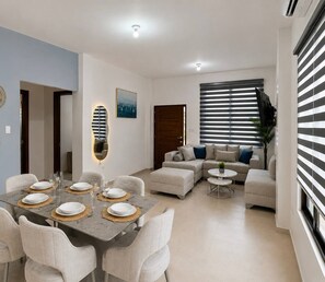 Una sala de estar moderna con comedor, que incluye un juego de sofá, una mesa de centro y un comedor listo para seis personas.