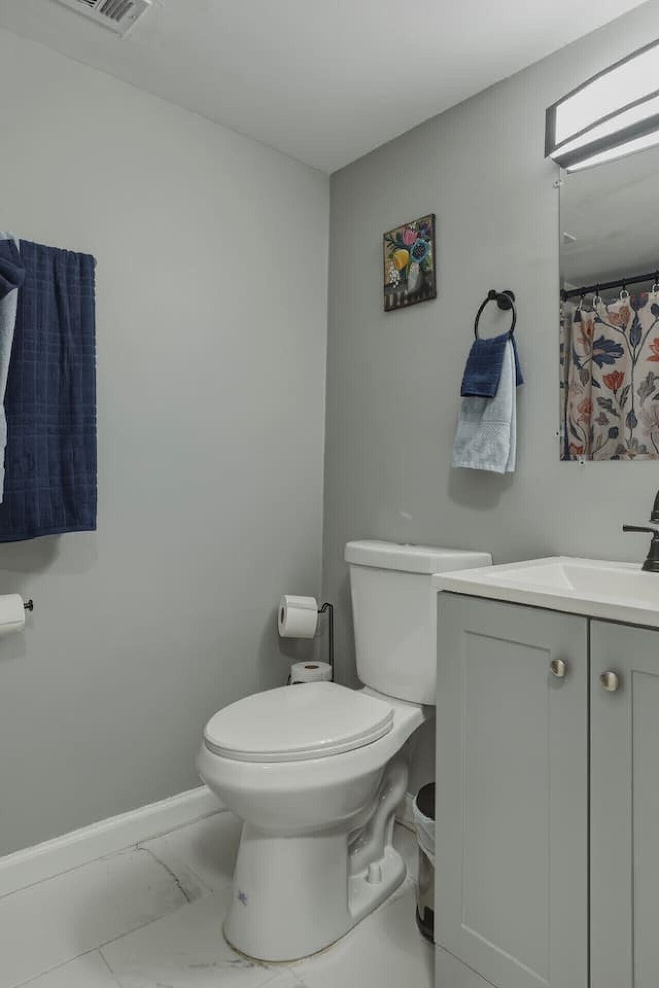 Un baño con inodoro, lavabo y cortina de ducha.