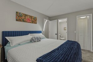 Un dormitorio con cama, mesita de noche, puerta y armario.