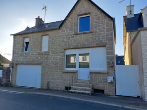 A two-story stone house with a garage, a small window, and a chimney. - townhouse (plouezec)