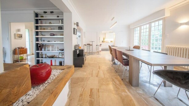 Un interior moderno con comedor, cocina y estanterías abiertas.