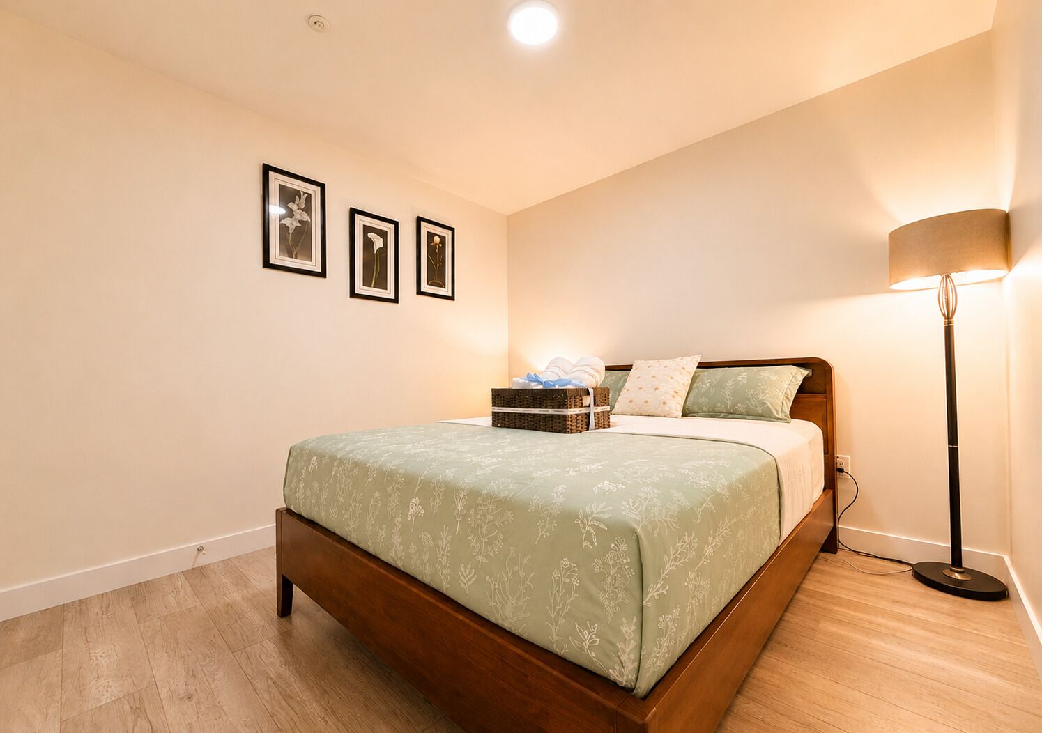Une chambre à coucher avec un lit en bois, une table de chevet surmontée d’un panier et une lampe sur pied.