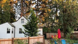 A backyard with a wooden deck, a small shed, and a stone pathway. - Artist's bungalow and garden in SE Portland (Milwaukie)