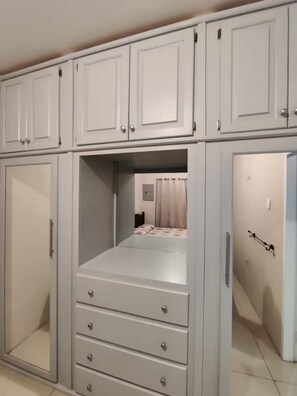 Ein Schlafzimmer mit einem Bett, einem Schminktisch und einem Kleiderschrank.