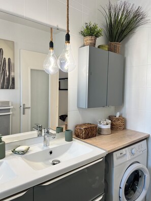 A modern bathroom with a sink, mirror, hanging light fixtures, and a washing machine. - Charming house & pool between Aix / Marseille (Gardanne)