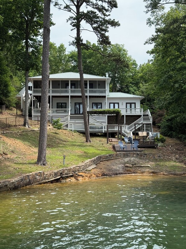 A two-story house with a porch and outdoor seating by a lake. - Family. Porches. Pets. Smith Lake. "Just Heavenly" (Arley)