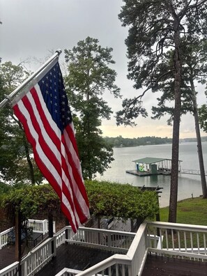 A flagpole with an American flag, a dock, and a lake view. - Family. Porches. Pets. Smith Lake. "Just Heavenly" (Arley)