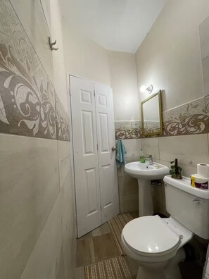 Ein Badezimmer mit Toilette, Waschbecken und Spiegel.