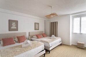 Ein Hotelzimmer mit zwei Betten, einem großen Fenster und einer Hängeleuchte.