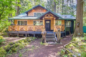 Eine Holzhütte mit Veranda, umgeben von Wald.