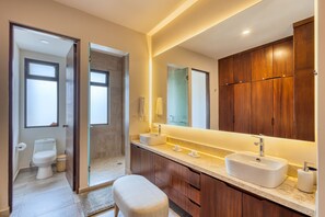 A modern bathroom with a double sink, wooden cabinets, and a large mirror. - Peaceful Coastal Stay With Pool, Balcony & Fitness Center (Cabo San Lucas)