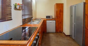 Une cuisine compacte équipée d’une cuisinière intégrée, d’un four à micro-ondes, d’un lave-vaisselle et d’un réfrigérateur.