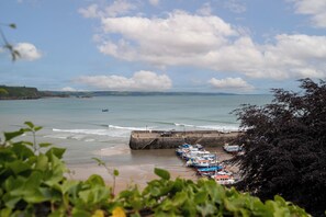 A coastal view with boats docked, a sandy beach, and a stone breakwater. - Tenby Harbour View - Heart of Tenby, Sea Views (Tenby)