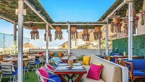 An outdoor seating area with tables and chairs, a sofa, and hanging decorations. - Cerro Colorado Studio Condo in Cabo San Lucas (Cabo San Lucas)