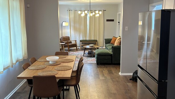 A modern kitchen with a dining area, wooden flooring, and a refrigerator. - Awesome 6-bedroom house with AC in vibrant Detroit (Detroit)