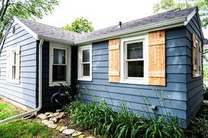 A house with a gabled roof, a front door, and a small porch area. - Newly Remodeled Riverfront Cottage (Rockford)