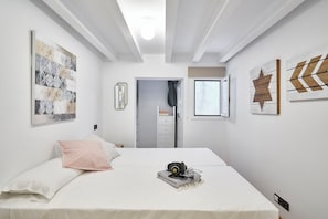 A bedroom with a bed, a window, and artwork on the walls. - Planell · BOLSA 2H - Two Bedroom Apartment, Sleeps 4 (Barcelona)