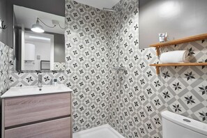 A bathroom with a shower, sink, mirror, and toilet. - Planell · BOLSA 2H - Two Bedroom Apartment, Sleeps 4 (Barcelona)