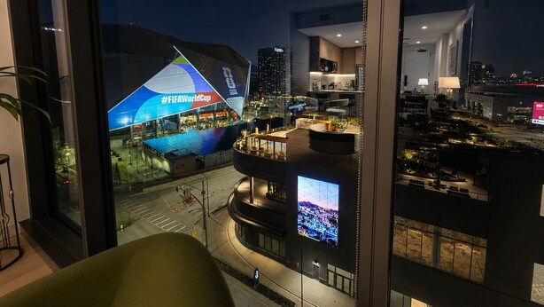 A modern building with a large digital display advertising the FIFA World Cup, a well-lit interior with a seating area, and a view of the cityscape at night. - Prime Atlanta Location 2026 Flat close to everything! (Atlanta)