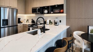 A modern kitchen with a central island, stainless steel appliances, and a built-in microwave shelf. - Prime Atlanta Location 2026 Flat close to everything! (Atlanta)
