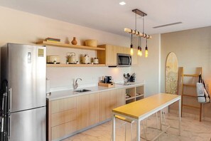 Eine moderne Küche mit einem Edelstahl-Kühlschrank, Holzschränken, einer Mikrowelle und einem Holztisch.