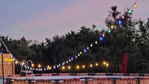 A wooden deck with a string of colorful lights, a ladder, and some hoses. - Cozy 2-bedroom apartment is amazing  peaceful some call it a gem. (Kempner)