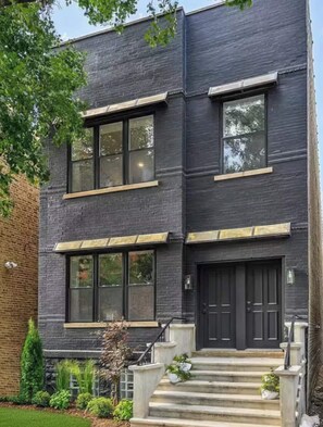 Un bâtiment moderne à deux étages, doté de grandes fenêtres et d’une façade sombre.
