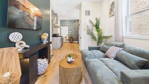 A modern living room with a sofa, a coffee table, and a painting on the wall.
