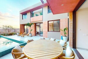 A modern house with a pool, outdoor seating, and potted plants. - Luxury House With Private Pool, Ocean View, Inviting Balcony & Elegant Charm (San José del Cabo)