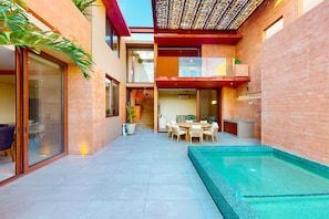 A modern house with a swimming pool, a dining area, and a staircase leading to an upper level. - Luxury House With Private Pool, Ocean View, Inviting Balcony & Elegant Charm (San José del Cabo)